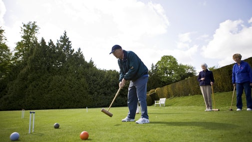 A man and two ladies playing croquet at Polesden Lacey
